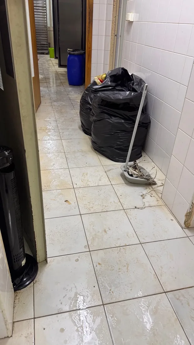 Pavimento sujo com resíduos e sacos de lixo, antes da limpeza geral